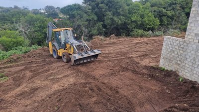 A backhoe loader levelling a site before foundations.