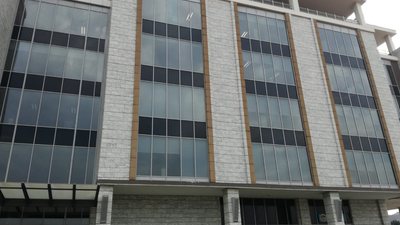 A multi-storey office block with glazed curtain walling and stone cladding.