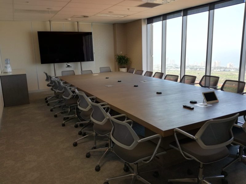 A finished boardroom with a long table and full-height glazing.