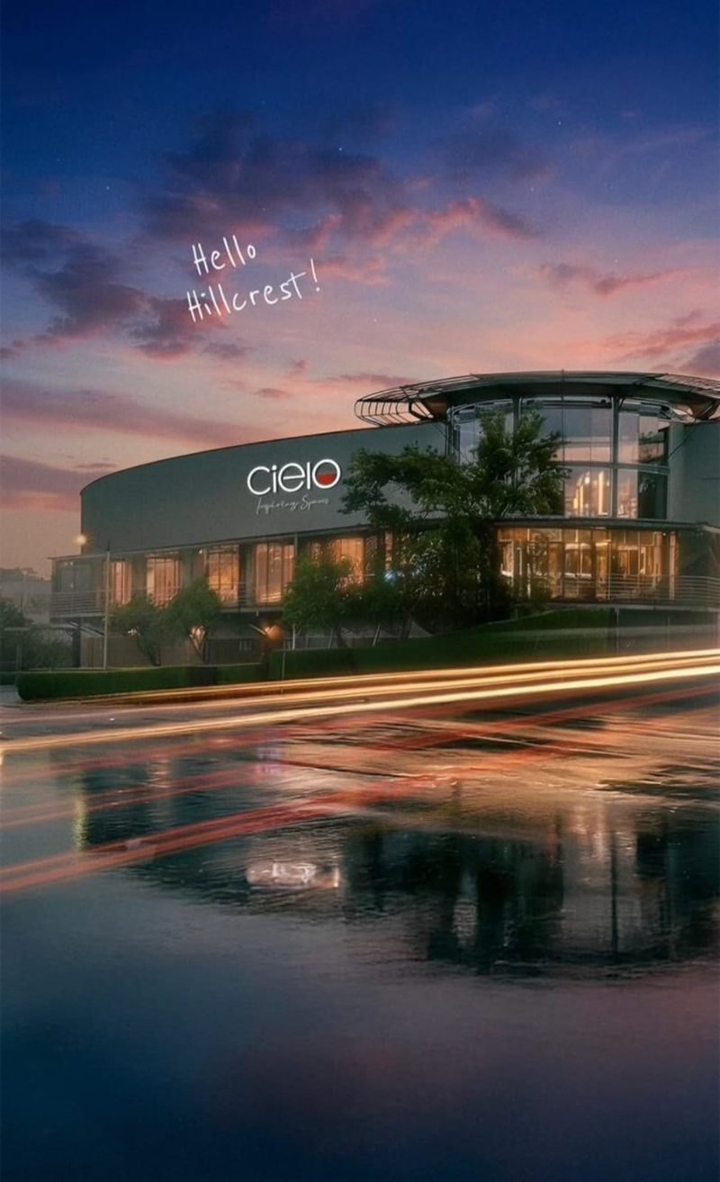 A retail centre at dusk seen from the approach road.