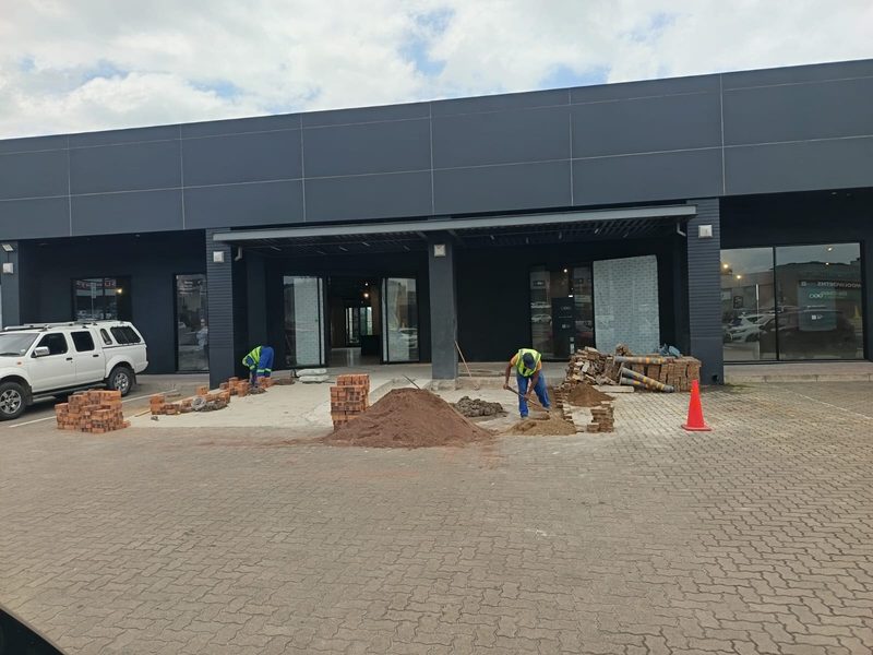 A commercial building frontage with paving under construction outside.