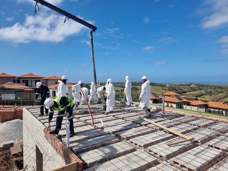 A crew placing and levelling concrete across a suspended slab.