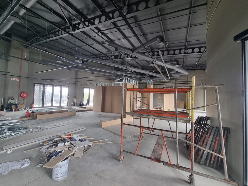 A mobile scaffold tower set up for ceiling work inside a commercial unit.