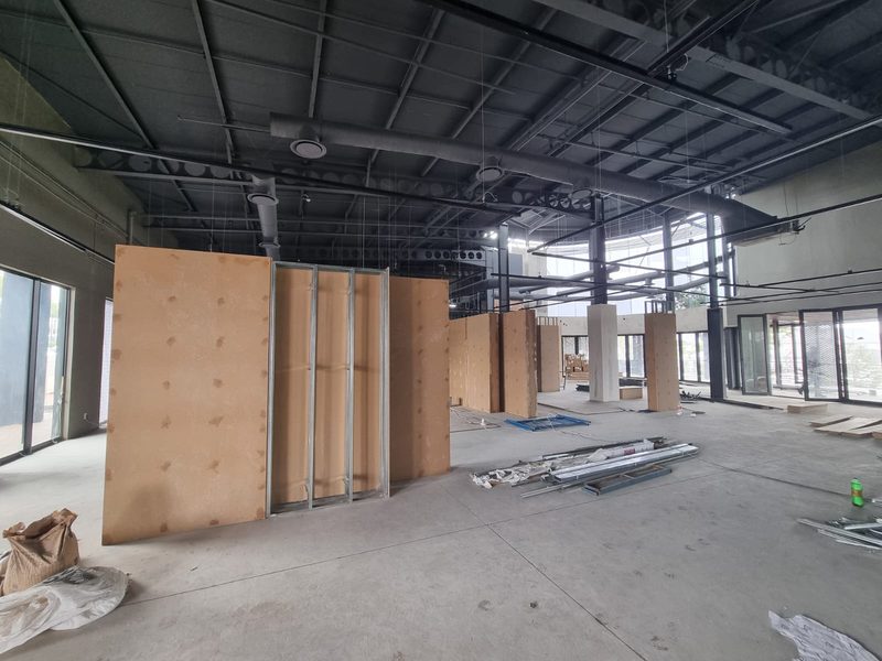 Partition walls being framed inside a commercial unit with exposed ceiling services.