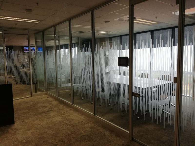 Glazed office partitions with vertical manifestation film.