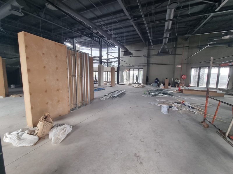 The interior of a commercial unit being fitted out, with exposed steel ceiling services.