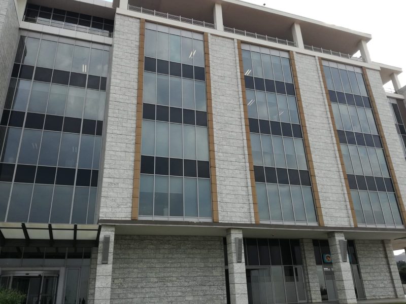 A multi-storey office block with glazed curtain walling and stone cladding.
