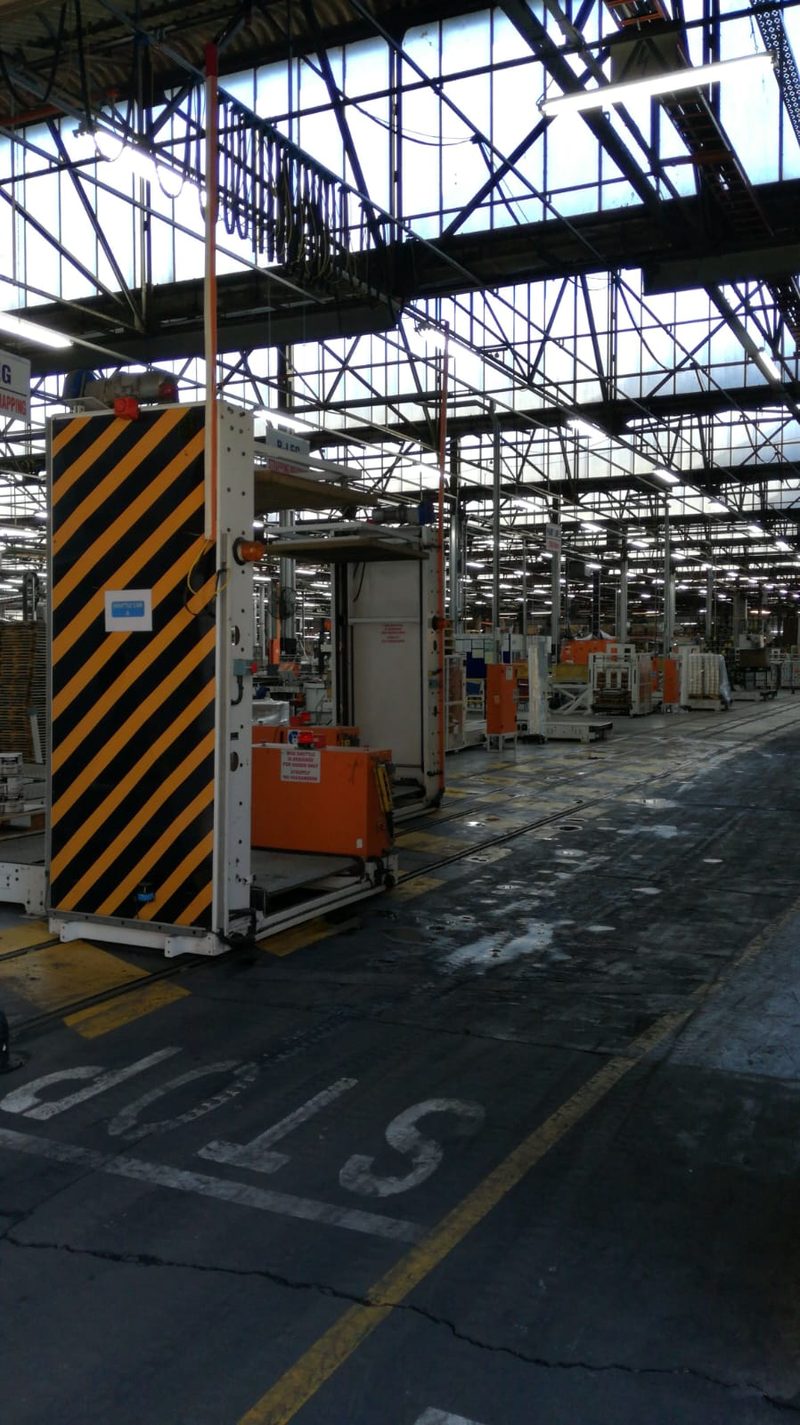 A working factory floor with materials handling equipment under a steel roof.