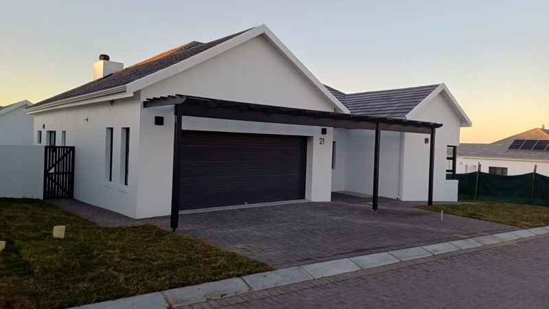 A completed single-storey home with a carport photographed at dusk.