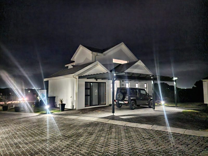 A completed home lit by external lighting at night.
