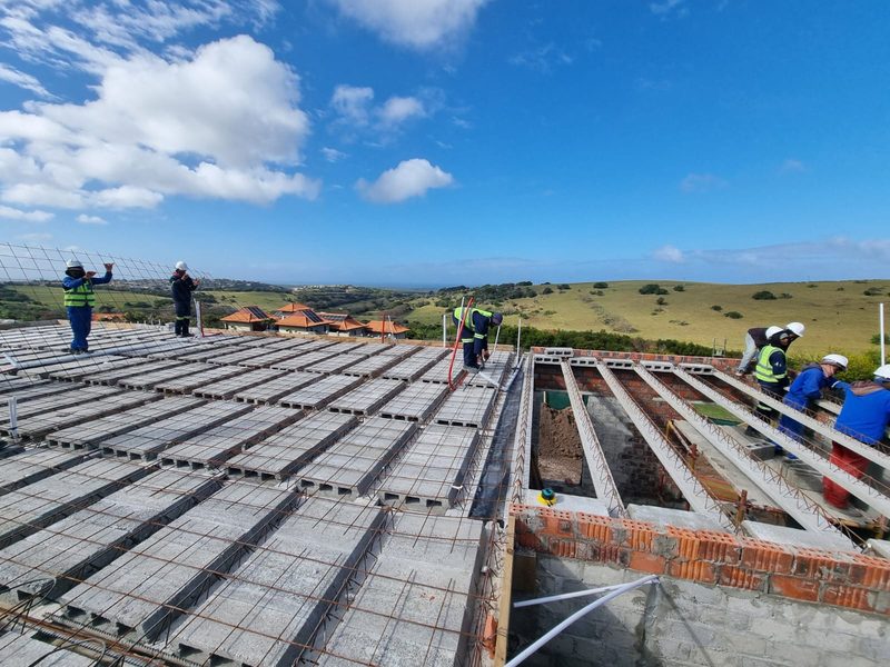 A crew laying rib-and-block flooring across a floor plate.