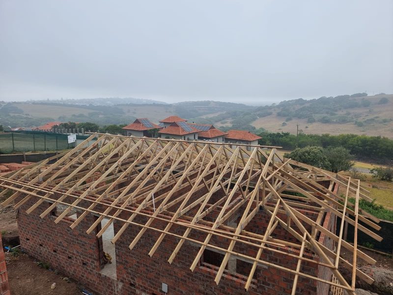 A timber roof structure set out over new face brick walls.