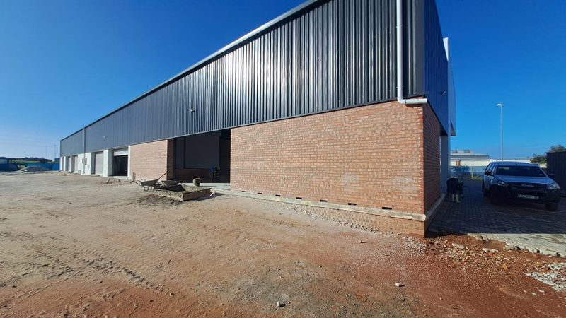 The side elevation of a warehouse combining face brick and profiled metal cladding.